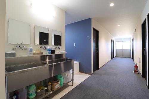 a large bathroom with two sinks and a blue wall at SWELL in Hyuga