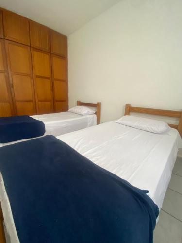 two twin beds in a room withthritisthritisthritisthritisthritisthritisthritisthritisthritis at Apart Cavalari Kitnets in Marília