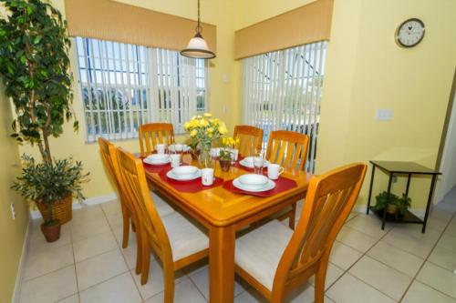 a dining room with a wooden table and chairs at Home With A View! in Orlando