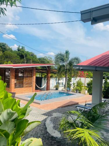 a house with a swimming pool in a yard at Rooma Kichi Private Pool in Pantai Cenang