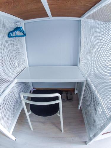 a white desk and a chair in a room at The Moon Hostel Huahin in Hua Hin