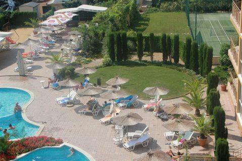 a group of chairs and umbrellas next to a pool at Elias Apartment in Golden Sands