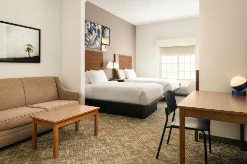 a hotel room with two beds and a couch at City Express by Marriott Danville in Danville