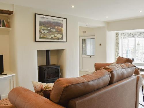 a living room with a leather couch and a fireplace at Rooftops - Uk34065 in Grassington