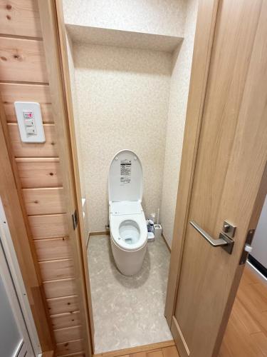 ein Badezimmer mit Toilette in einem kleinen Zimmer in der Unterkunft 最大4名の城ノ浜プール近くの宿 in Kihokucho