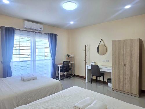 a bedroom with two beds and a desk and a mirror at Hatyai Luxe Stay 2BR Private House up to 8 Guests near Hat Yai Park in Hat Yai