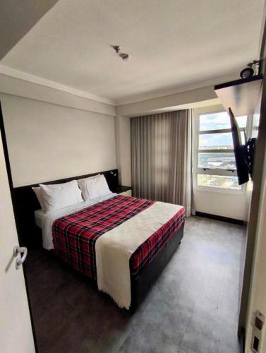 a hotel room with a bed and a window at Hotel Guarulhos Flat 2004 in Guarulhos