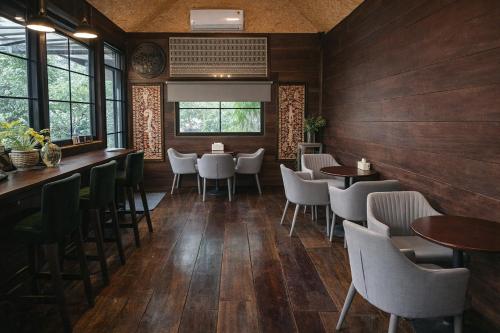 a restaurant with wooden walls and tables and chairs at Rayong Valley Resort in Ban Khao Chak Khaek (1)