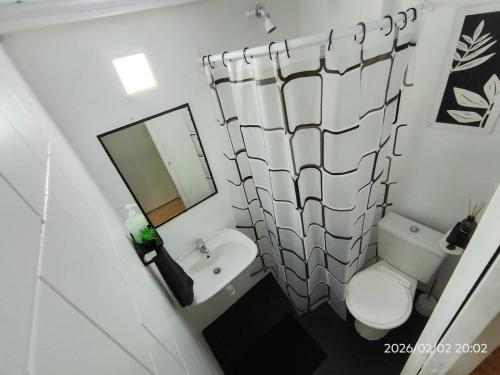 a bathroom with a toilet and a sink and a mirror at departamento completo, Luminoso, cómodo y bien ubicado ideal eventos river movistar arena tecnopolis in Munro