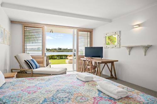 a bedroom with a bed and a desk and a television at Noosa Quays Waterfront Accomodation in Noosa Heads