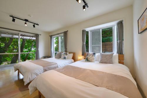 two beds in a room with two windows at 064Villa 美海璃 in Nanjo