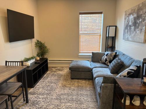 a living room with a couch and a flat screen tv at Aisling Suites in Great Falls
