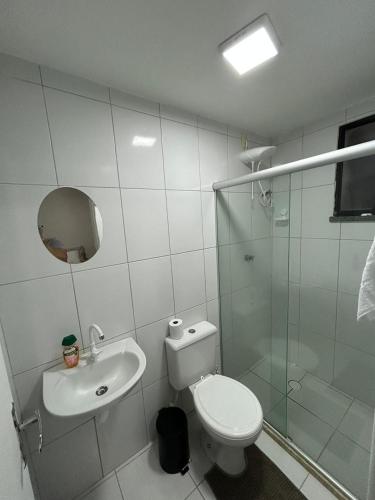 a bathroom with a toilet and a glass shower at Cantinho da Aruana, conforto e tranquilidade in Aracaju