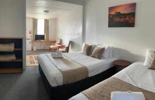 a hotel room with two beds and a living room at Berridale Inn in Berridale