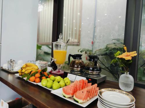 a table with a tray of fruit and a drink at Dragon Mountain Home in Ninh Binh - Center Of Heritage in Ninh Binh