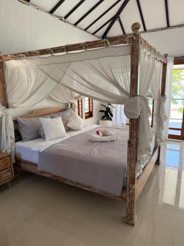 a bedroom with a wooden bed with a canopy at Twin Palms Rote in Nembrala