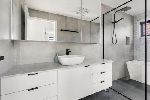 a white bathroom with a sink and a shower at Coastal Ember in Inverloch