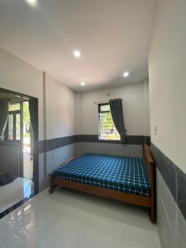 a bedroom with a bed in a room with a window at Tổ Nhím Homestay in Ấp Cái Chuối