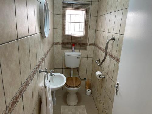R&A Cottage في ويندهوك: حمام مزود بمرحاض ومغسلة