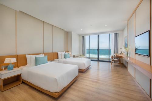 a hotel room with two beds and a view of the ocean at TMS Hotel Da Nang Beach in Danang