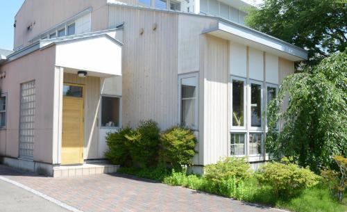 a house with a yellow door on the side of it at YUKARA-YA YA - Vacation STAY 18011 in Ōnuma