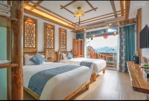 a hotel room with two beds and a balcony at Tu Wang Ju Ke Zhan in Yongshun