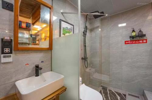 a bathroom with a sink and a shower at Tu Wang Ju Ke Zhan in Yongshun