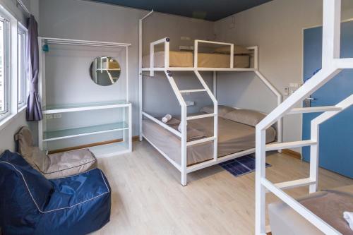 a small room with bunk beds and a ladder at The Moon Hostel Huahin in Hua Hin