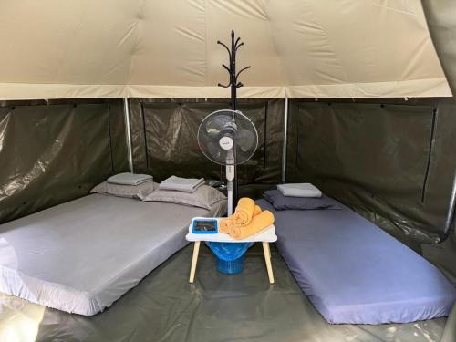 a room with two beds and a fan in a tent at Rasa Durio Eco Glampz in Rasa