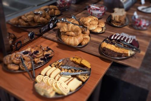 a table filled with different types of pastries and pies at Manjimup Motor Inn in Manjimup