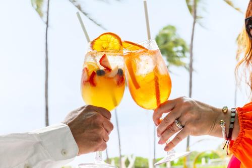 two people holding up two glasses of mimosas at Waldorf Towers South Beach in Miami Beach