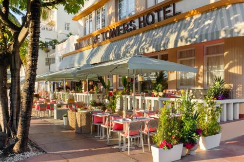 an outdoor restaurant with tables and chairs and umbrellas at Waldorf Towers South Beach in Miami Beach