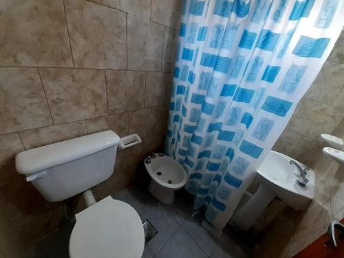 a bathroom with a toilet and a shower curtain at Gotas de Rocío - para 4 en San Antonio Oeste in San Antonio Oeste