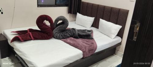 two black swans are sitting on a bed at Hotel Rainbow palace in Ujjain