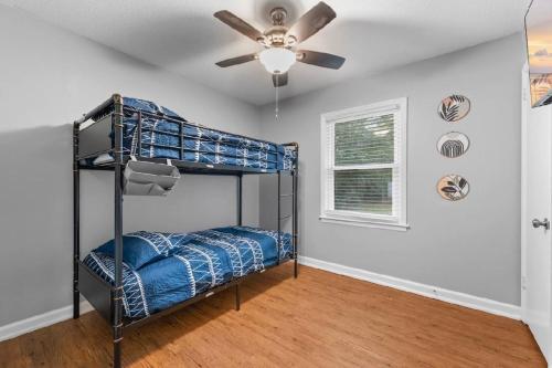 a bedroom with a bunk bed and a ceiling fan at Summerville’s Tea House in Summerville