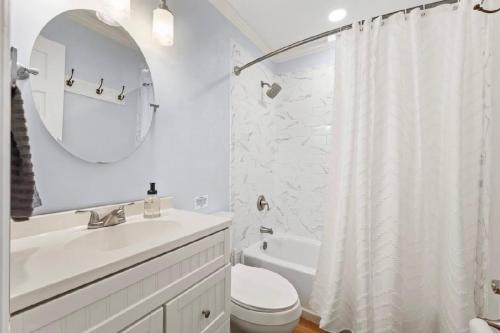a bathroom with a sink and a toilet and a mirror at Summerville’s Tea House in Summerville