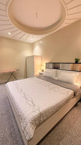 a bedroom with a large bed with a ceiling at مسكن الفخامة in Taif