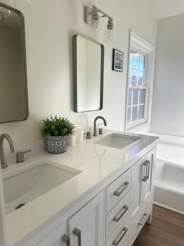 a white bathroom with a sink and a mirror at Summerville’s Charm House in Summerville