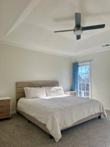 a bedroom with a bed with a ceiling fan at Summerville’s Charm House in Summerville