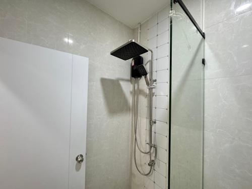a shower with a shower head in a bathroom at Villa nabon in Ban Suan