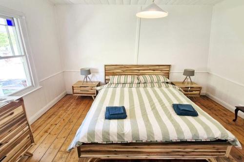 a bedroom with a bed with two blue pillows on it at A Warm & Charming Retreat in Castlemaine