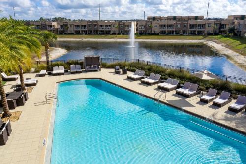 a swimming pool with lounge chairs and a fountain at Stunning 4 Bd Close To Disney @ Magic Village 3247 in Orlando