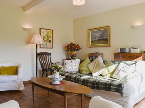 a living room with a couch and a table at Coachmans Close in Milverton