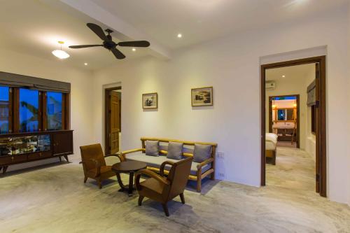 a living room with a ceiling fan and a table and chairs at Vina Beach Pool Villas in Hoi An