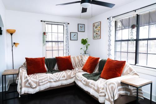 a living room with a couch with orange and white pillows at Hidden Gem Near Plaza Mall - Mi Casita McAllen in McAllen