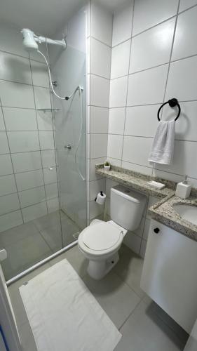 a white bathroom with a toilet and a shower at Ap Mirante Fortaleza 5min da Praia com Piscina e Rooftop para 6 pessoas in Fortaleza
