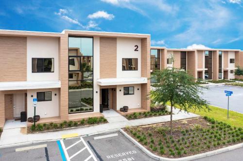 an image of an apartment building with a parking lot at Gorgeous 4Bd Close to Disney @ Magic Village 7581 in Orlando