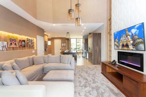 a living room with a white couch and a flat screen tv at Gorgeous 4Bd Close to Disney @ Magic Village 7581 in Orlando