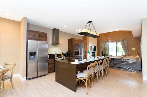 a kitchen with a large island with a bar with chairs at Gorgeous 4Bd Close to Disney @ Magic Village 7581 in Orlando