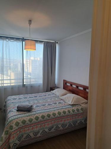 a bedroom with a bed with a window and a bed sidx sidx sidx at Agradable Dpto Calama Centro in Calama